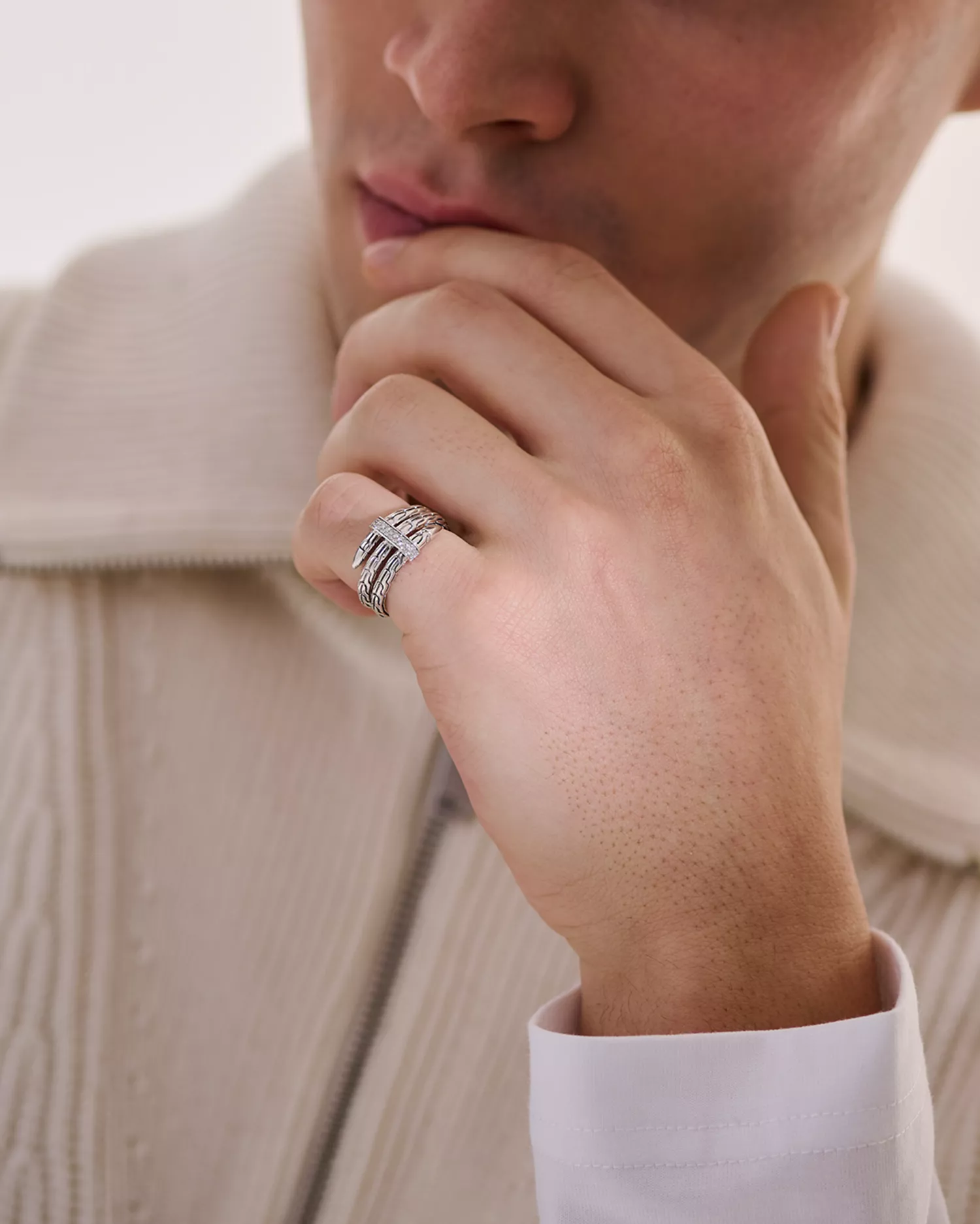 Close-up of a man wearing the John Hardy Diamond Coil Ring, photographed in a soft, minimalist fashion setting.